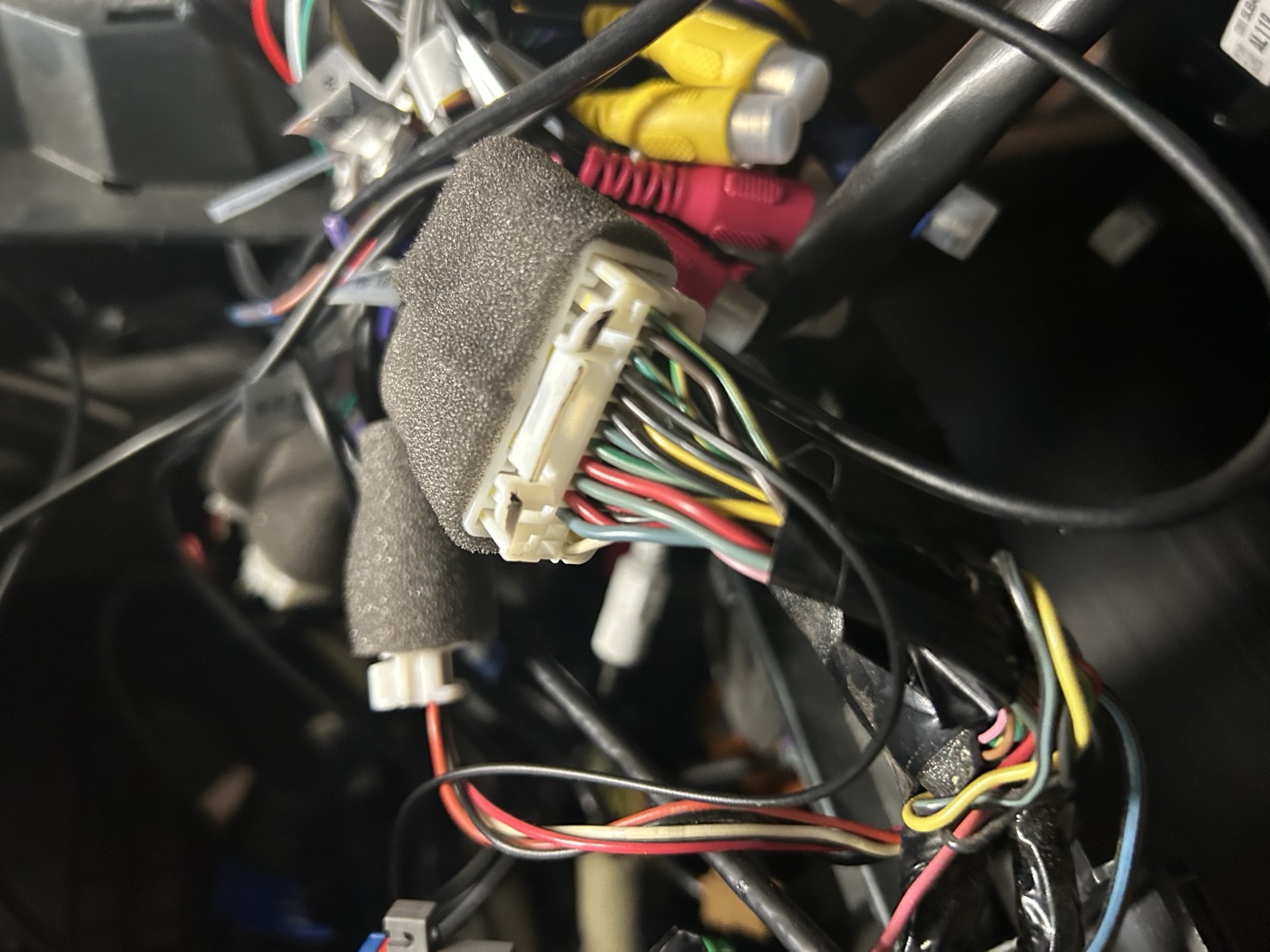 A white multi-way connector on the radio harness with a red wire running into a small separate white housing below it — the added 5V feed for the microphone.